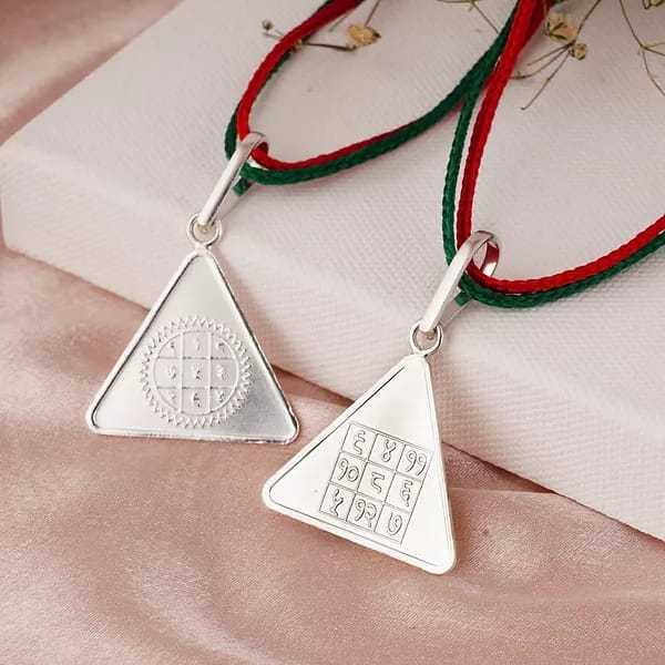 Triangular Surya Budh Yantra pendants with red and green threads for mental clarity and success.