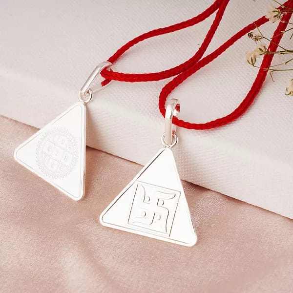 Silver Surya Yantra pendant with red thread, symbolizing vitality and positive energy.
