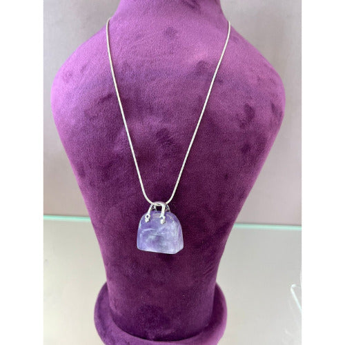 Relic of the Reef Pendant made from fossil stone displayed on a purple mannequin.