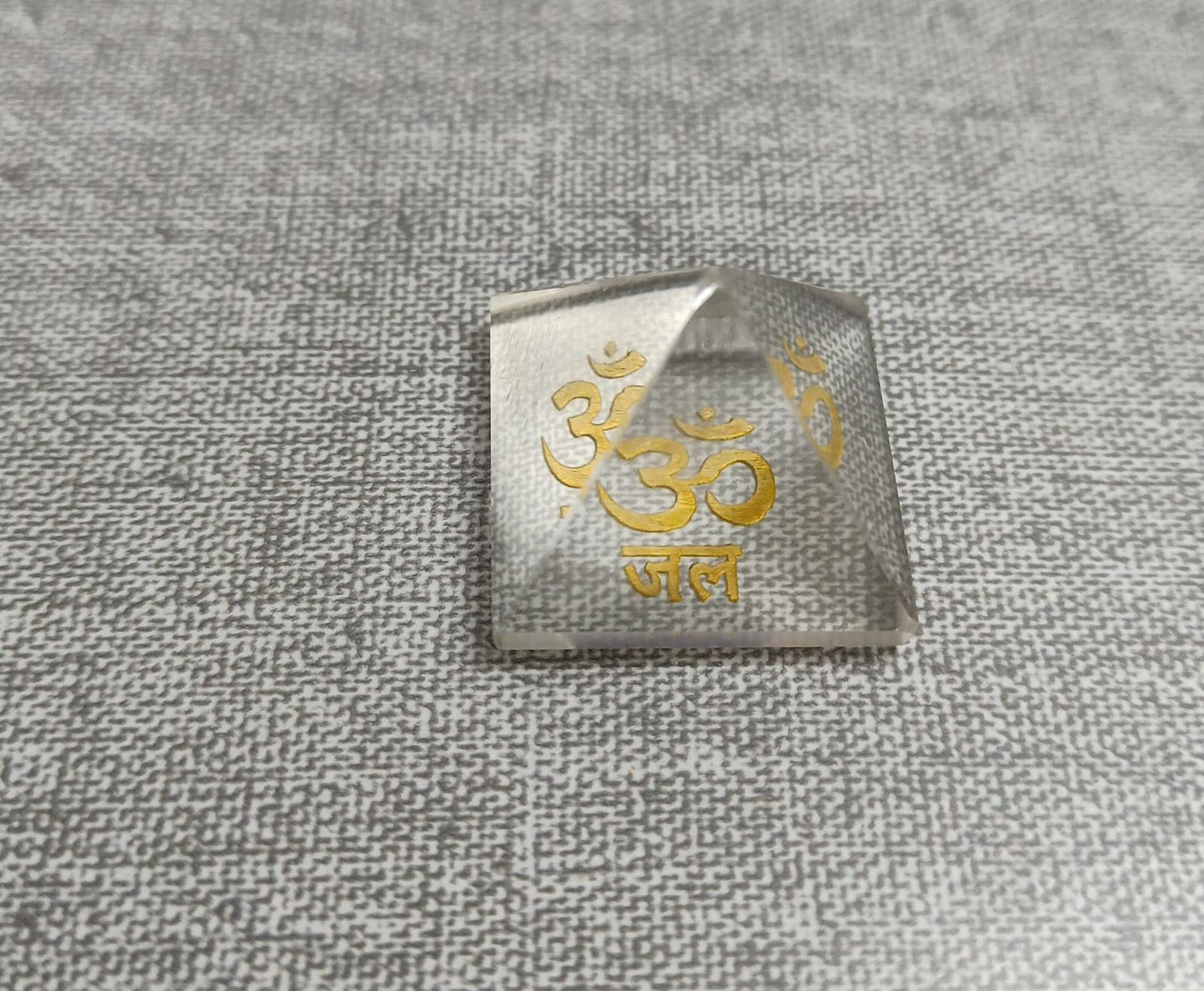 Om Jal Pyramid with gold Om symbol, enhances energy for meditation and manifestation.