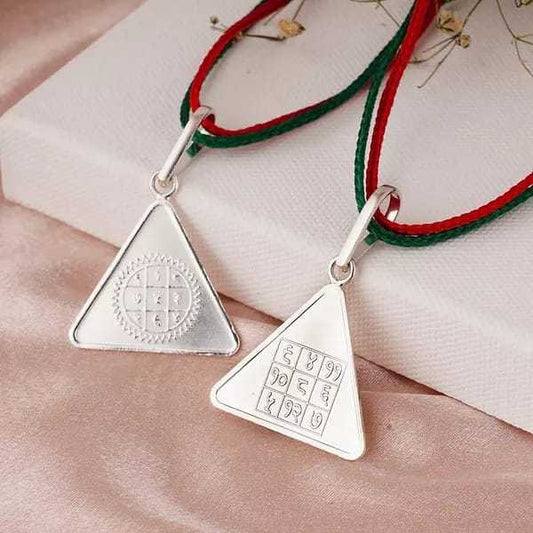 Triangular Surya Budh Yantra pendants with red and green threads for mental clarity and success.
