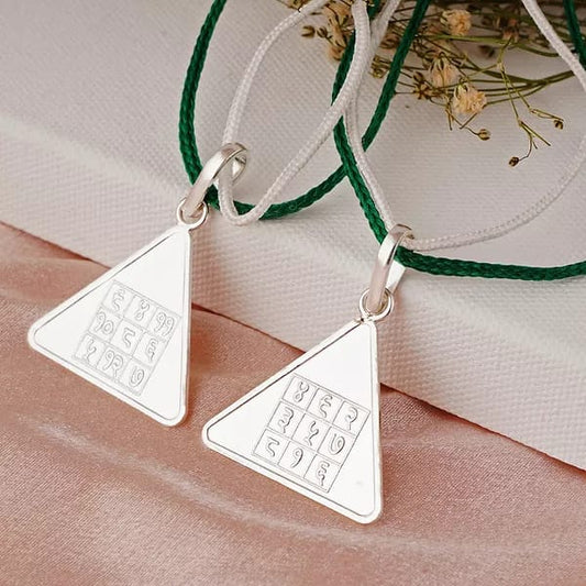 Triangular Budh Pyra Yantra pendants on a fabric surface, enhancing communication and intellect.