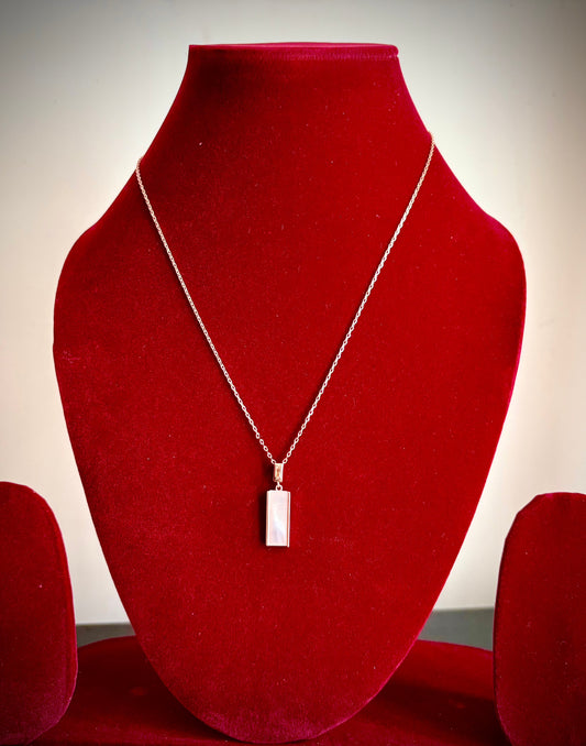 Moon’s Embrace Silver Pearl Pendant on red display.