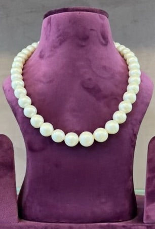 Diana Pearl Necklace displayed on purple stand, featuring genuine pearls.