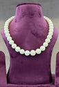 Diana Pearl Necklace displayed on purple stand, featuring genuine pearls.
