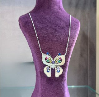 Wings of Astraea Silver Pendant with elegant design on purple display.