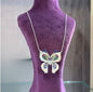 Wings of Astraea Silver Pendant with elegant design on purple display.