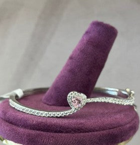 Heart of Lyra Silver Bracelet on purple display, elegant and symbolic design.