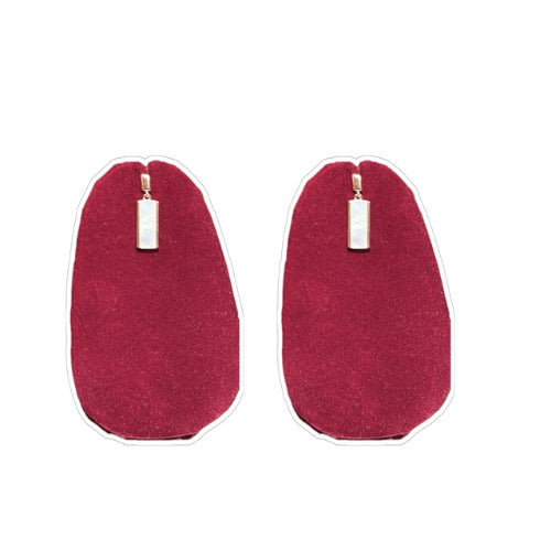 Moon’s Embrace Silver Earrings with pearl accent on red background.