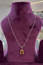 Aurya Lux Silver Pendant displayed on a purple velvet stand.